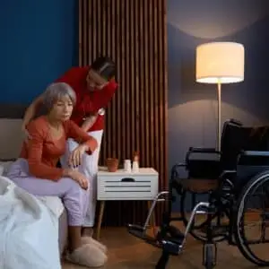 Caregiver assisting elderly woman at home.