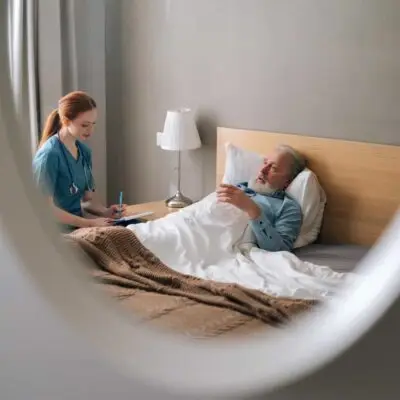 Nurse attending to patient in bed.