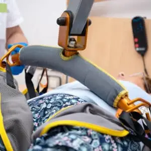 Patient being assisted with lifting device